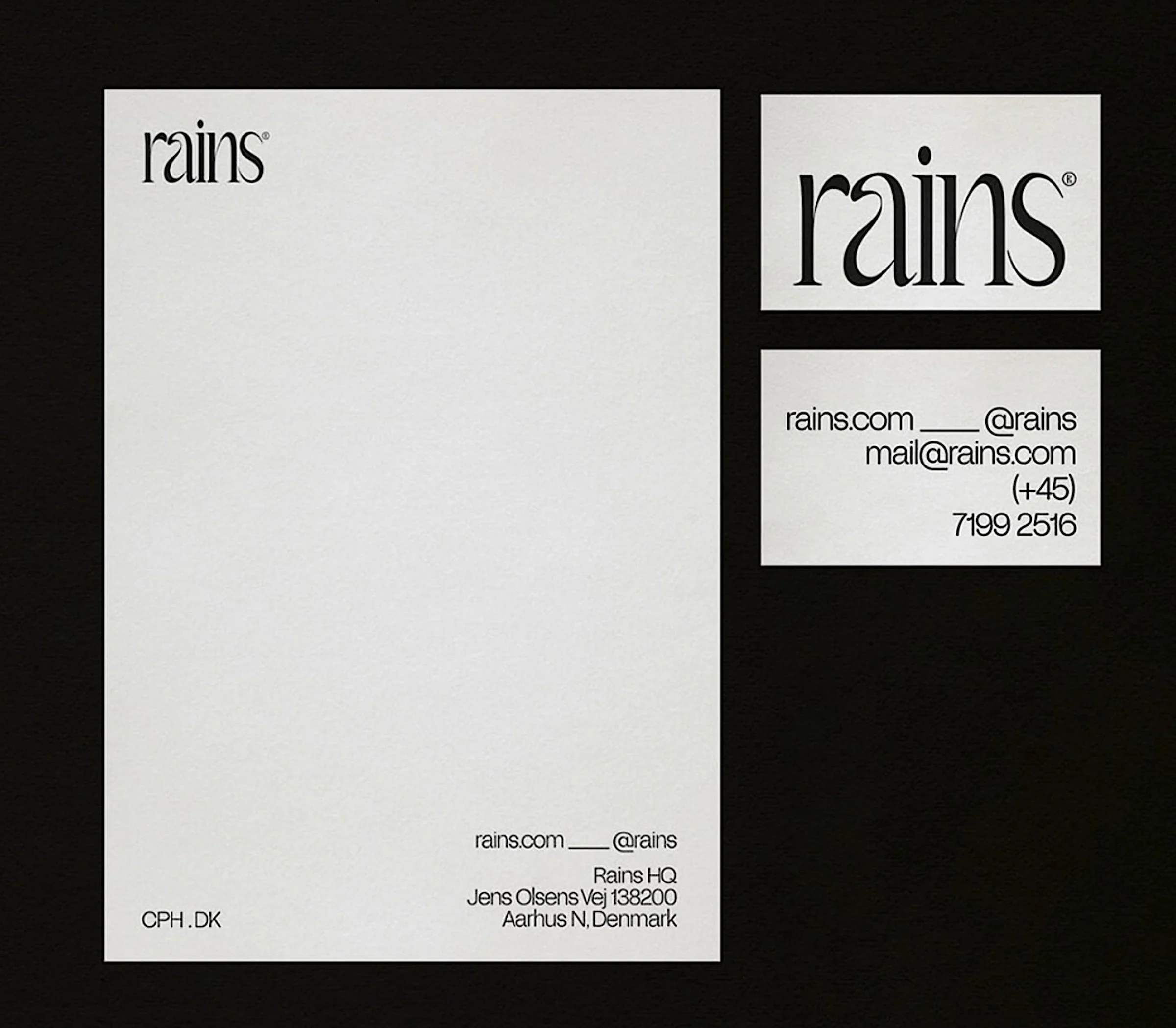 Letterhead and business card front and back with black serif wordmark on off-white paper over a black background, for Rains.