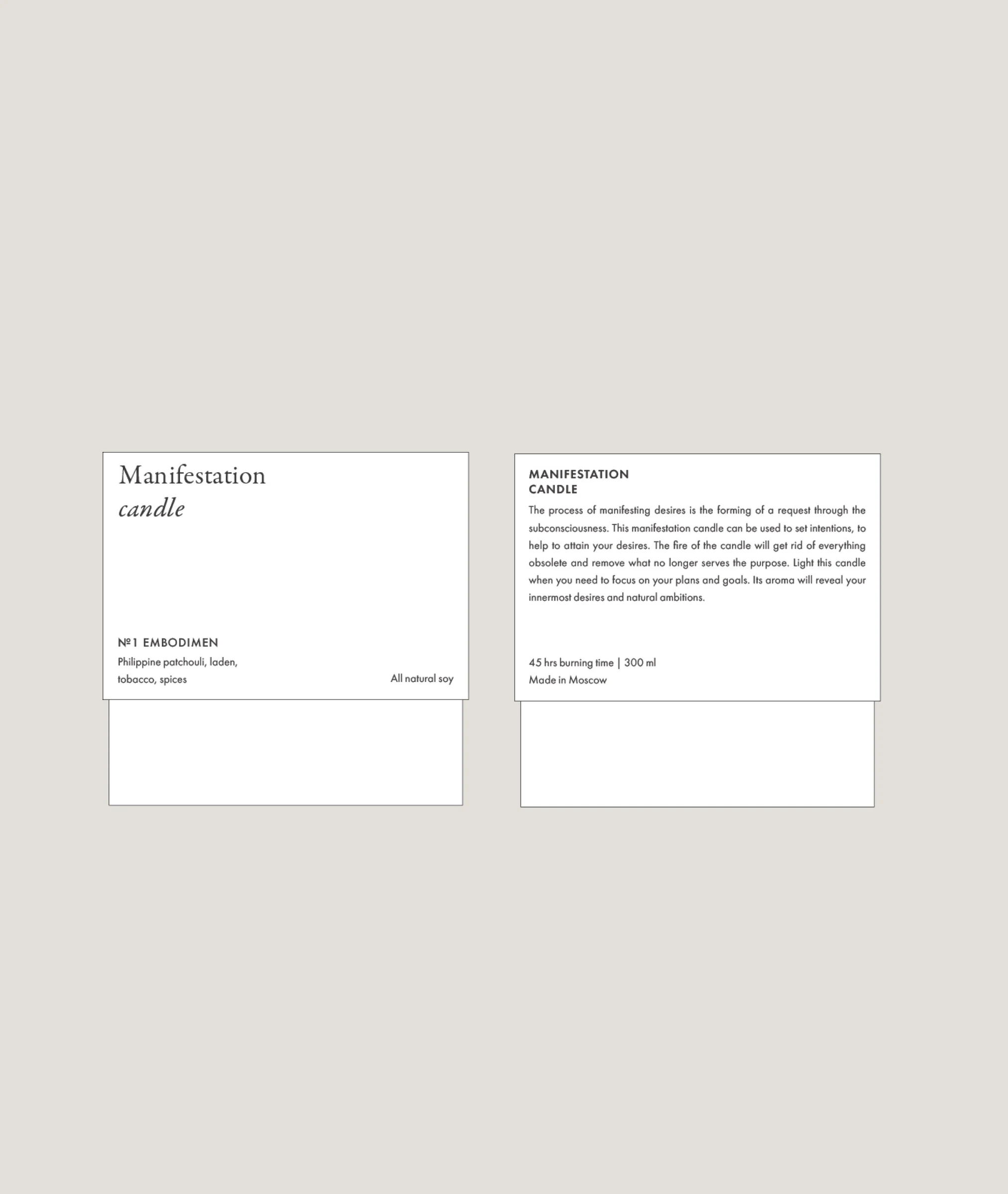 Front and back white candle labels with serif title, scent notes and description on a grey background, for Manifestation Candles.