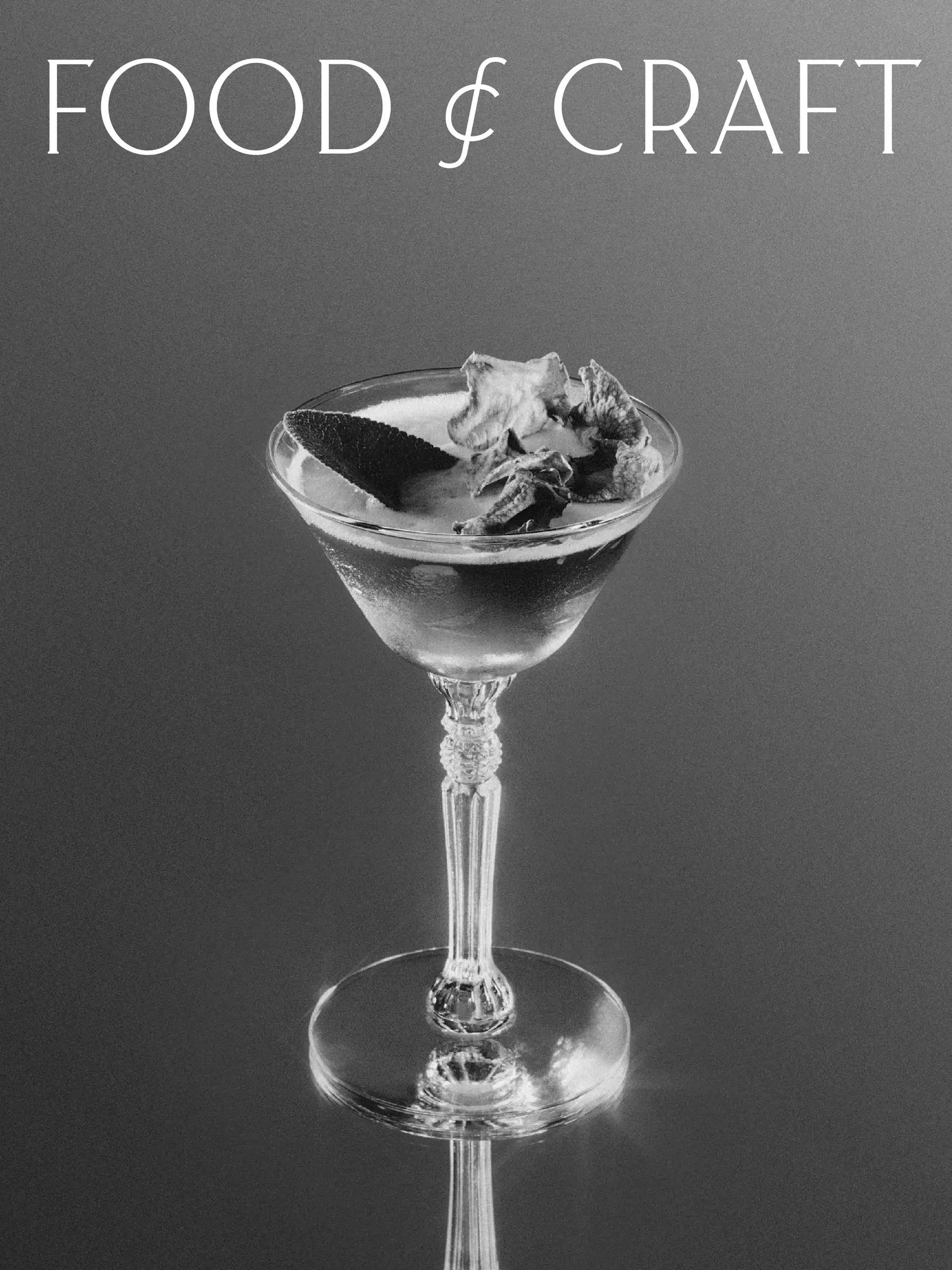 Black and white photo of a stemmed cocktail glass with leaf garnish under the Food & Craft wordmark, for Food & Craft.