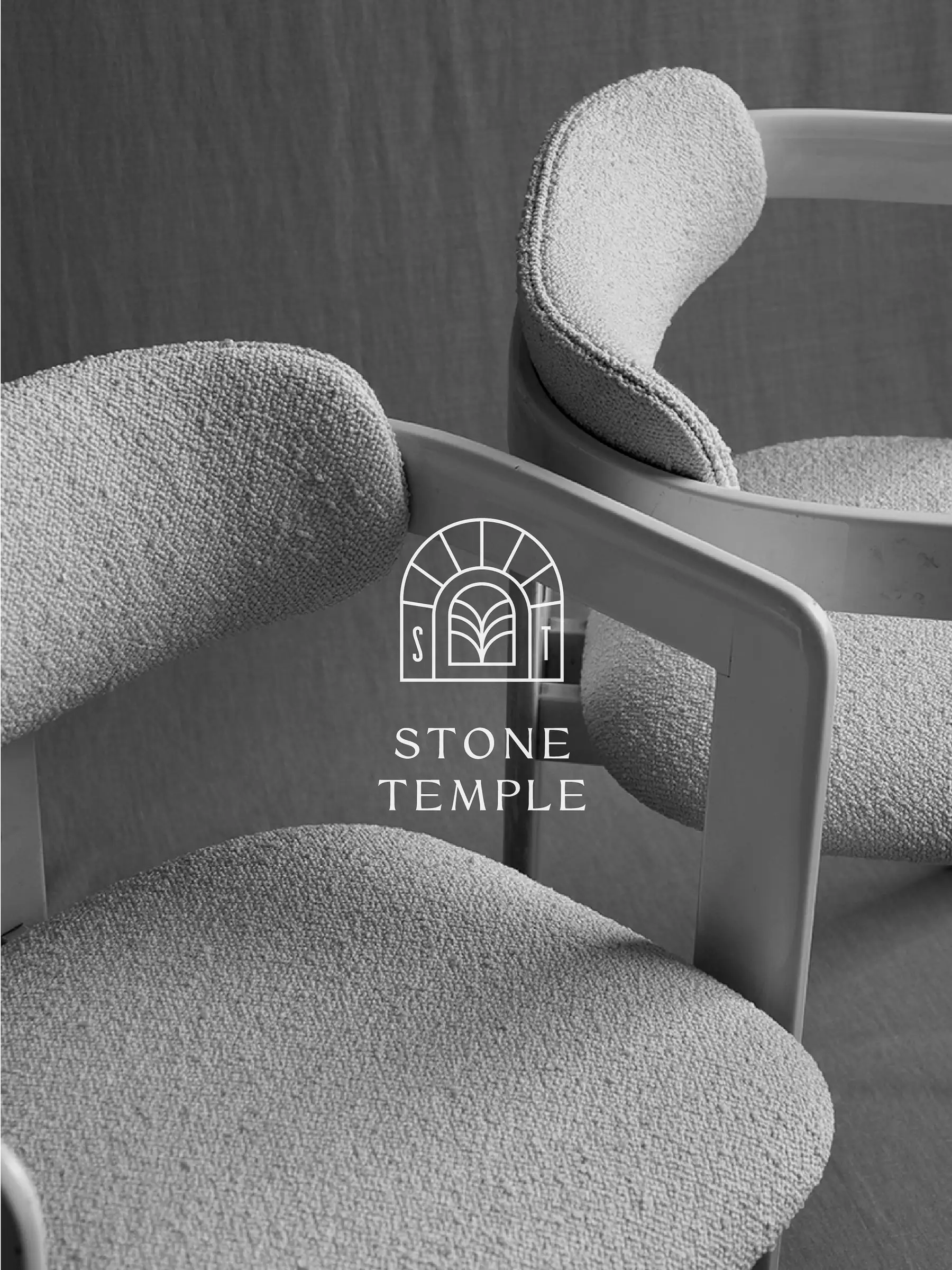 Stone Temple arch logo in white over black-and-white photo of two bouclé dining chairs, for Stone Temple.