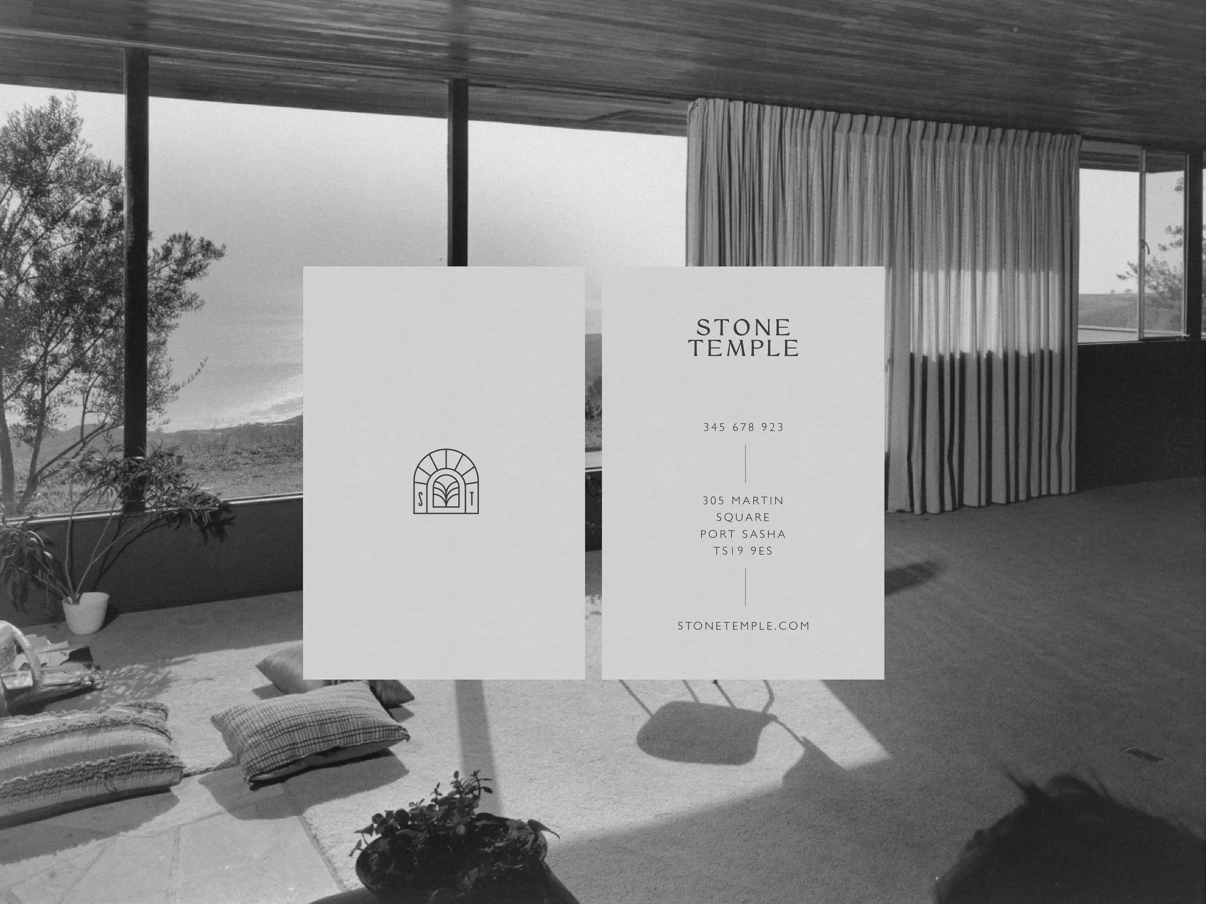 Business card front with arched monogram and back with contact details, over a black-and-white interior, for Stone Temple.
