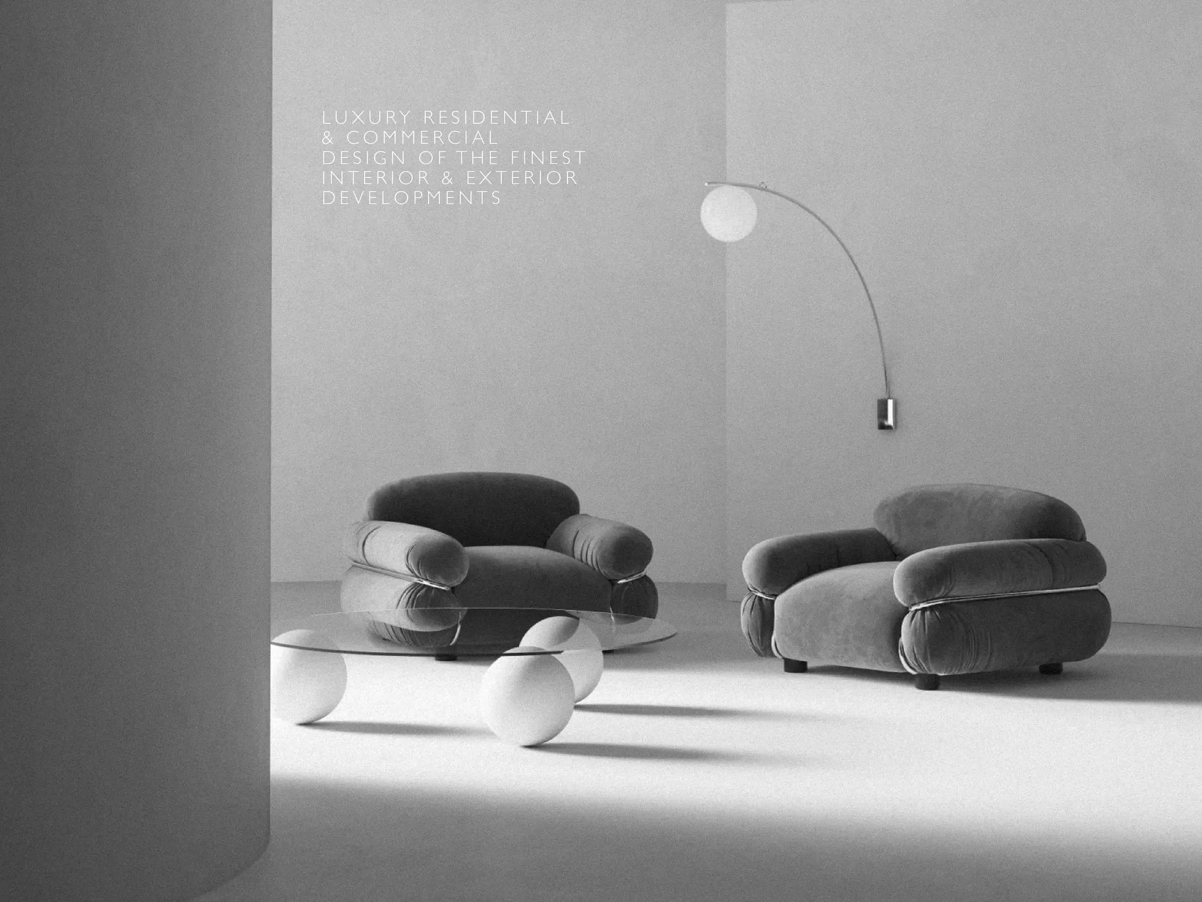 Grey velvet armchairs, glass table on white spheres and arc lamp in a pale room with a white text overlay, for Stone Temple.