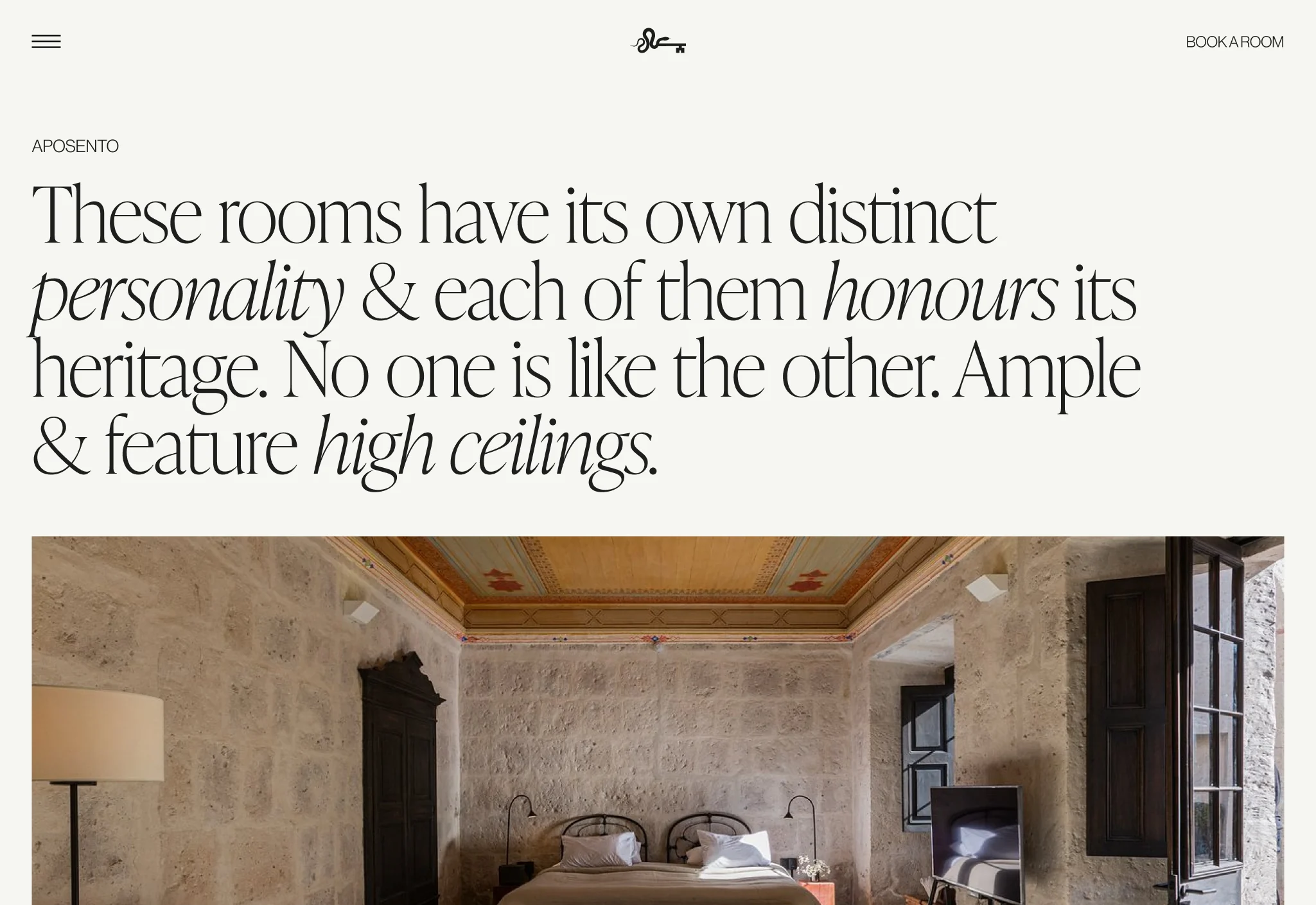 Website rooms page with serif headline about heritage rooms above a stone-walled bedroom with painted ceiling, for Cirqa.